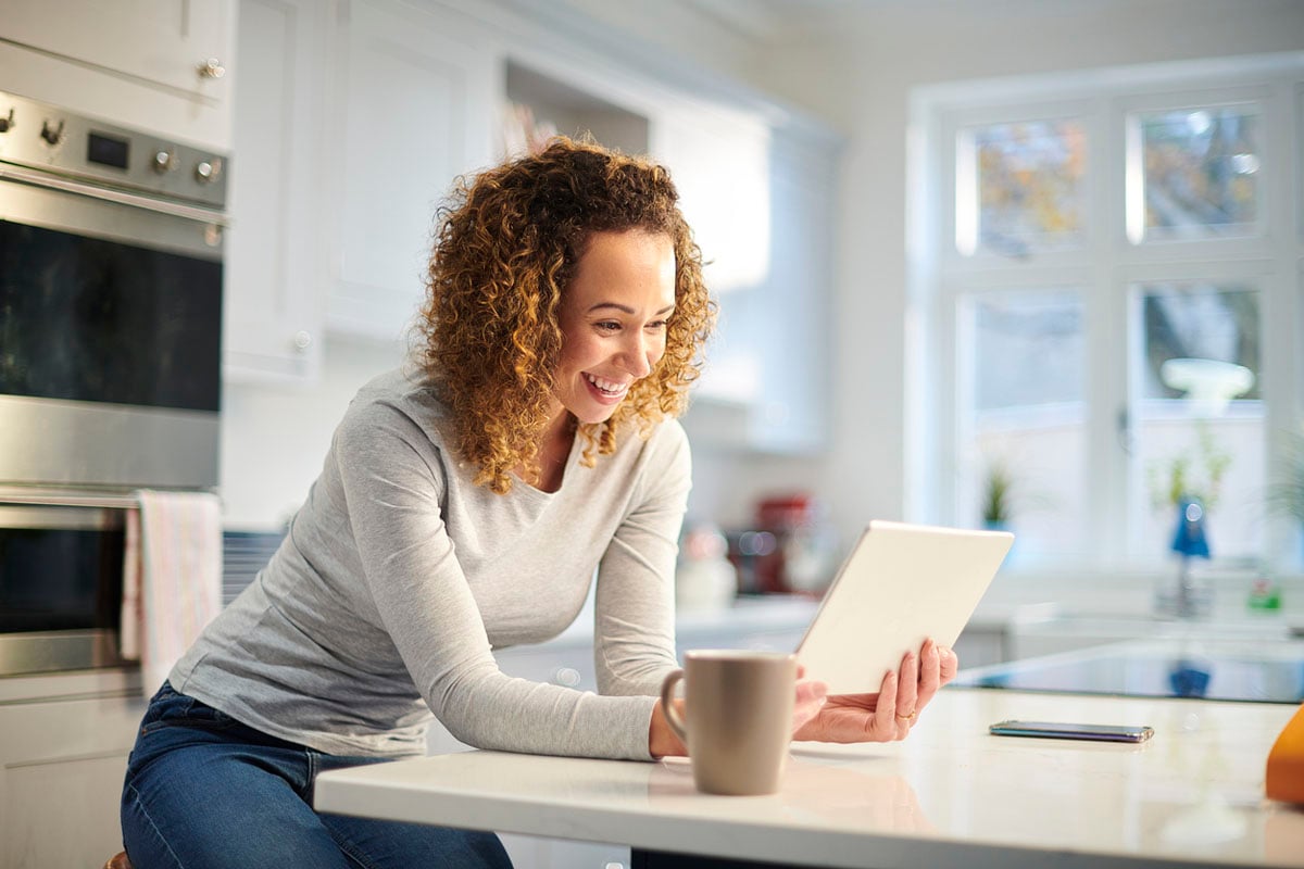 woman in kitchen using ipad